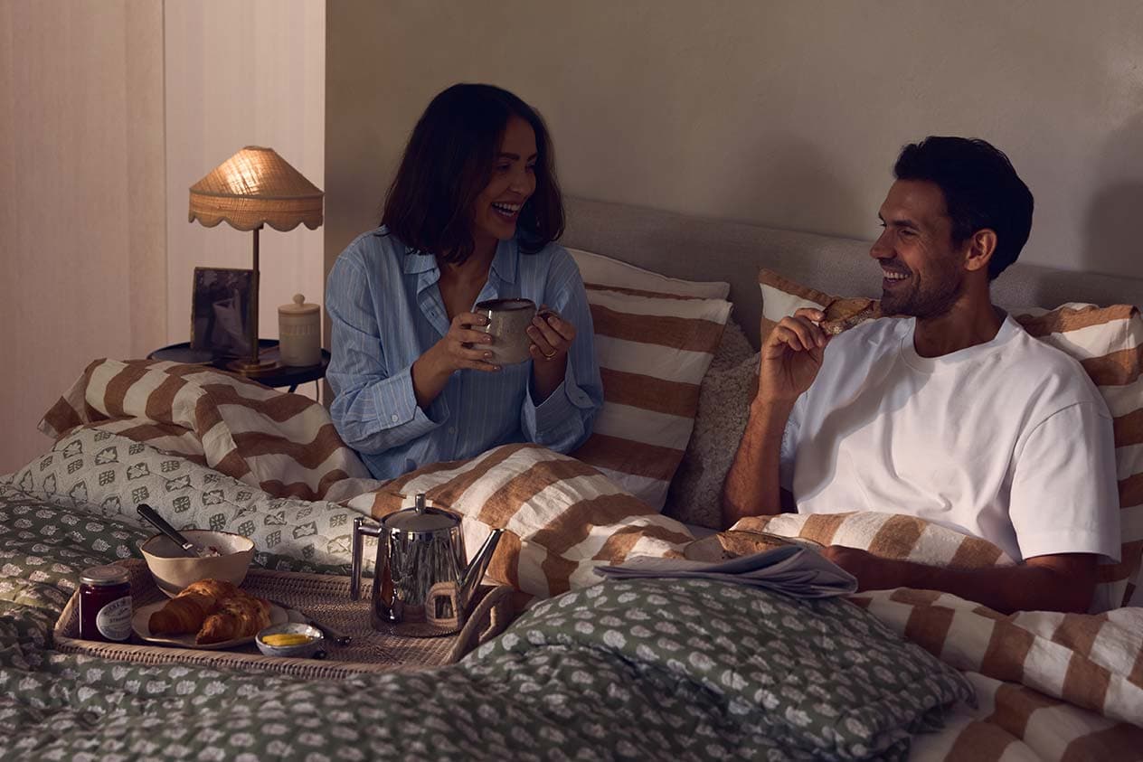 A couple enjoys breakfast in bed