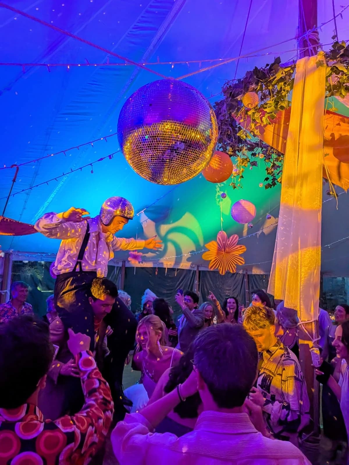 Studio 54 themed festival wedding in Scotland, with a giant disco ball and colourful fabric over a packed marquee dance floor