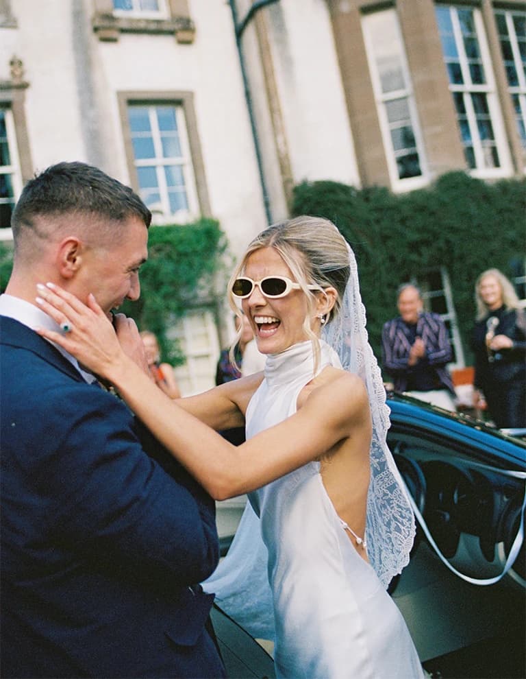 Newlyweds celebrating outside a historic family estate in Scotland